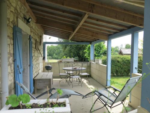 patio z krzesłami, stołem i krzesłami w obiekcie Holiday Home Gîte Le Landhuismes - HUI100 by Interhome w mieście Huismes