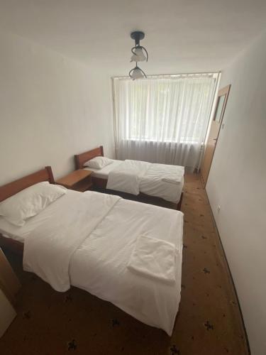 2 camas individuales en una habitación con ventana en Leśna Polana, en Sękocin Stary