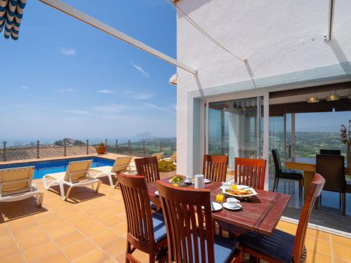 a patio with a table and chairs and a pool at Holiday Home Stuttgart by Interhome in Cumbre del Sol