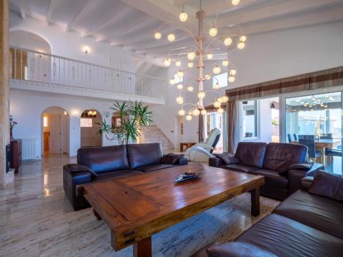 a living room with couches and a wooden table at Holiday Home Stuttgart by Interhome in Cumbre del Sol