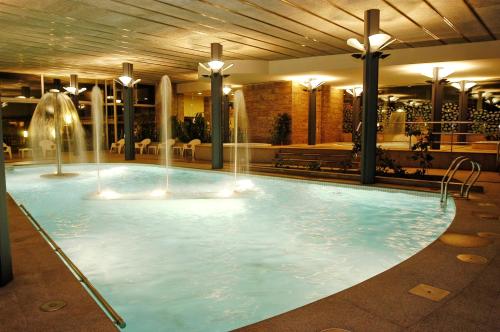 a swimming pool with a large fountain in the middle of it at Mercure Andorra in Andorra la Vella