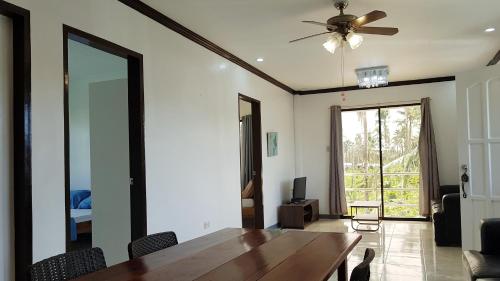 a dining room with a table and a ceiling fan at Yayay Homestay in General Luna