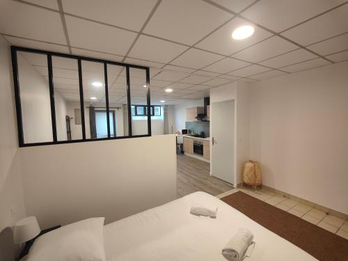 サン・テニャンにあるStudio des quaisの壁に大きな鏡がある大きな白い部屋