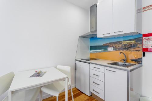 a small kitchen with a sink and a desk at Real Home in Sacavém