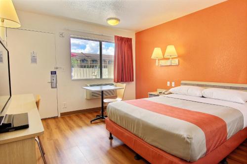Una habitación de hotel con una cama, un escritorio y una ventana. en Motel 6-Kingsville, TX, en Kingsville