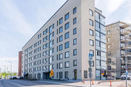un edificio blanco alto en una calle de la ciudad en Cozy apartment right next to metro station, en Espoo