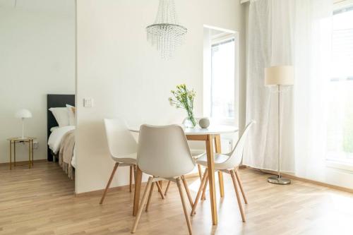 a dining room with a table and chairs and a bed at Cozy apartment right next to metro station in Espoo