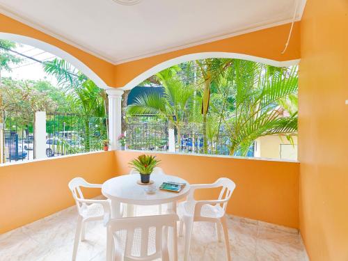 a white table and chairs in a room with windows at Parco del Caribe in Boca Chica