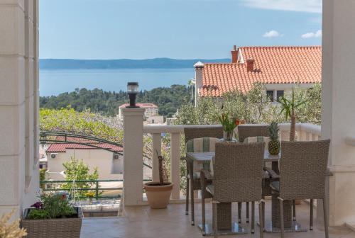 a balcony with a table and chairs and a view of the water at Villa Božica - sea view stone villa with free parking in Makarska