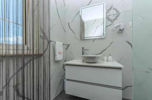 a bathroom with a sink and a mirror at Villa Božica - sea view stone villa with free parking in Makarska