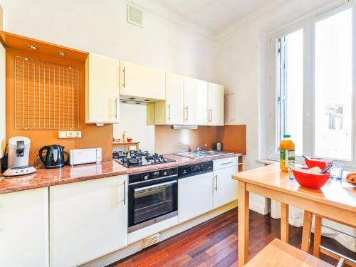 une cuisine avec des armoires blanches et une table en bois dans l'établissement Apartment Villa Chalmette by Interhome, à Cannes