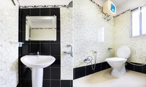 a bathroom with a white toilet and a sink at Treebo Concerto Residentia in Durgāpur