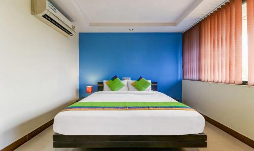 a bedroom with a large bed with a blue wall at Treebo Concerto Residentia in Durgāpur