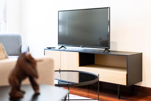 a person walking through a living room with a tv at Beach and Chill apartment by Cisan Rentals in Donostia-San Sebastián
