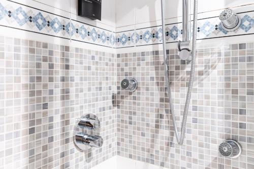 a bathroom with a shower with blue and white tiles at Beach and Chill apartment by Cisan Rentals in San Sebastián