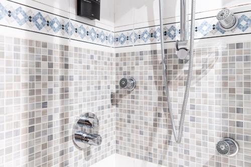 a bathroom with a shower with blue and white tiles at Beach and Chill apartment by Cisan Rentals in Donostia-San Sebastián