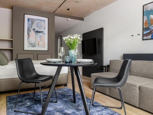 a living room with a table and chairs and a bed at Numa Munich Stark in Munich