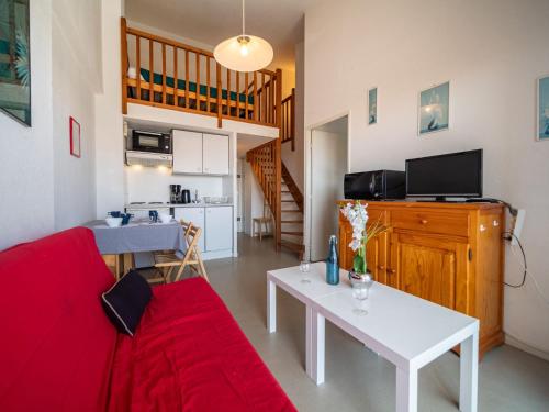 un salon avec un canapé rouge et une table dans l'établissement Apartment Les Flots Bleus by Interhome, au Barcarès