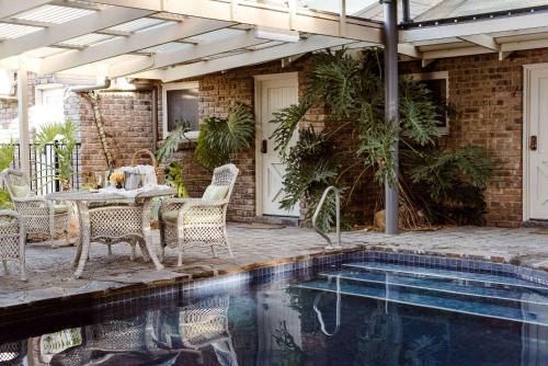 a patio with a table and chairs next to a pool at The Lodge in Hahndorf