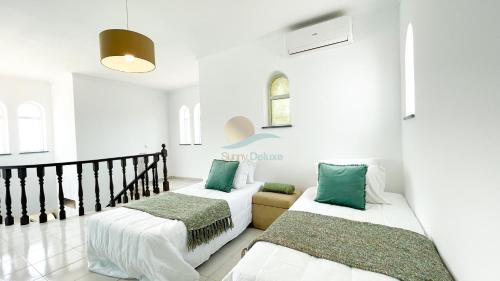 a room with two beds and a couch at Vila Ricardo by Sunny Deluxe in Albufeira