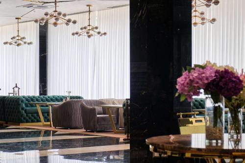 a living room with couches and tables and flowers at Panarams Tashkent Hotel, a member of Radisson Individuals in Tashkent