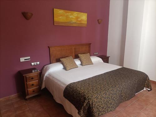 a bedroom with a bed and a purple wall at Hotel Galera in Galera