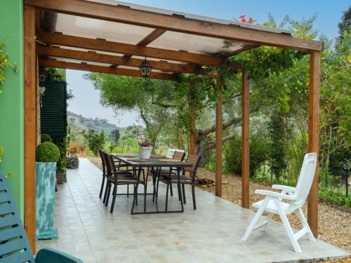 un pergolato in legno con tavolo e sedie su un patio di Holiday Home Rosa by Interhome a Civezza