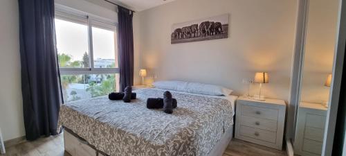 ein Schlafzimmer mit einem Bett mit zwei schwarzen Stofftieren darauf in der Unterkunft Homes of Spain, Apartamentos Paraíso, Ed Palmerston, Atico O, Suite con Piscina Privada en solárium, vistas al mar, a 50 m de la playa, WIFI in Playas de Vera