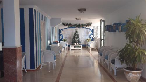 ein Wartezimmer mit weißen Stühlen und einem Weihnachtsbaum in der Unterkunft Las Faluas in Playa del Ingles