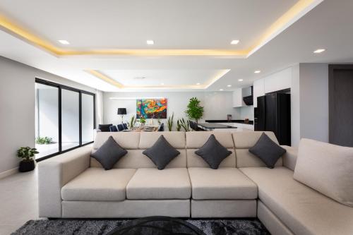 a living room with a large couch with pillows at Serenity Jomtien Pool Villas in Jomtien Beach