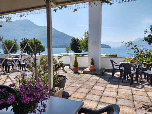 a patio with tables and chairs and a view of the ocean at Apartment Betti by Interhome in Domaso