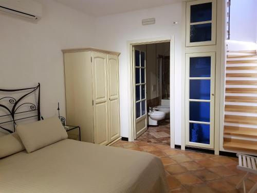 1 dormitorio con 1 cama y baño con aseo en Giasone Apartments, en Taormina