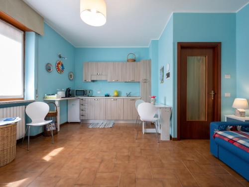 ein Wohnzimmer mit blauen Wänden und eine Küche in der Unterkunft Apartment Les Maisons della Fattoria 1 by Interhome in Omegna