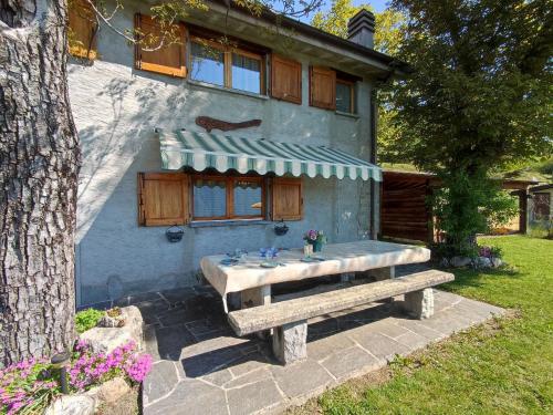 a house with a picnic table in front of it at Chalet Merlo by Interhome in Porlezza
