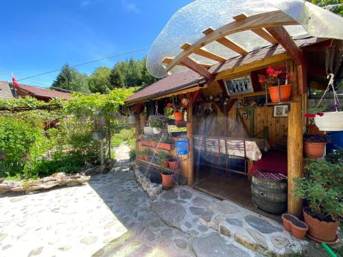 a small flower shop with a wooden roof at Pensiunea Mioritica in Sibiel
