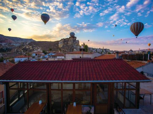 a group of hot air balloons flying over a city at Rose Valley Hotel in Goreme