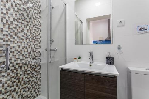 a bathroom with a sink and a shower at Real Home in Sacavém