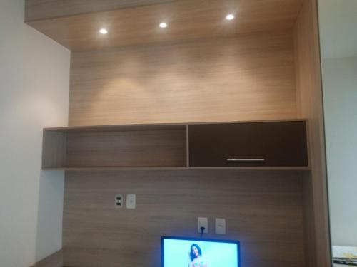 a flat screen tv sitting inside of a wooden wall at Excelente flat em Copacabana in Rio de Janeiro