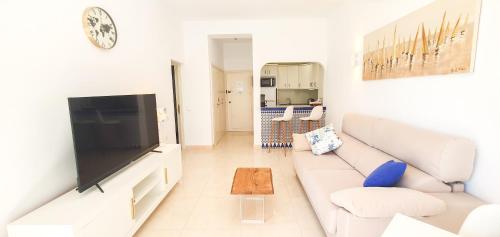 sala de estar con sofá blanco y TV grande en Skol 128 - Great 1-Bedroom Apartment with Sea Views, en Marbella