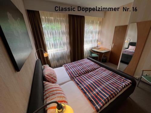 a hotel room with a bed with a striped blanket at HoteLPension am Thermalbad in Bad Nenndorf