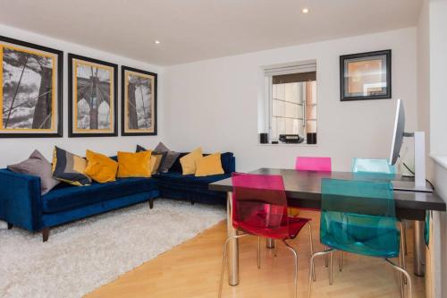 ロンドンにあるBeautiful 1 Bed Central London Apartmentのリビングルーム(青いソファ、カラフルな椅子付)