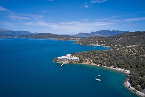 an island with a resort and boats in the water at Xenia Poros Image Hotel in Poros