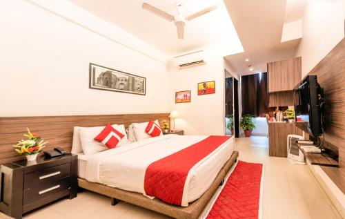 a bedroom with a bed and a flat screen tv at Octave Golfcourse Inn in Gurgaon