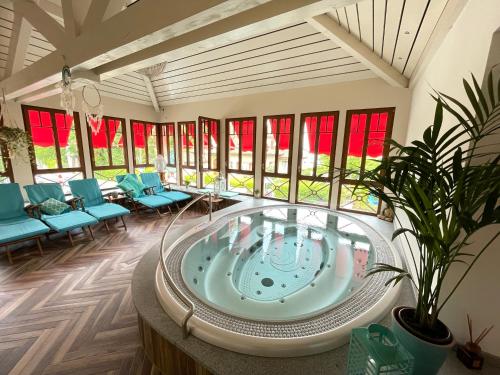 a hot tub in a room with blue chairs at Les Cygnes in Évian-les-Bains