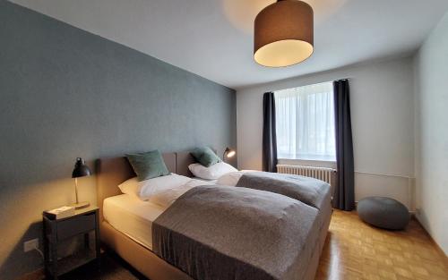 um quarto com 2 camas e uma grande janela em Apartment Via Surpunt - Perspektiva - 5 Rooms em St. Moritz