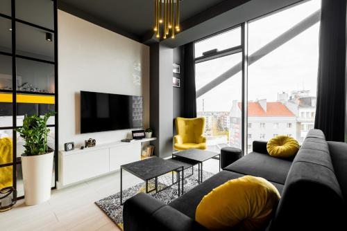 a living room with a couch and a tv at Q18 ApartHotel in Bydgoszcz