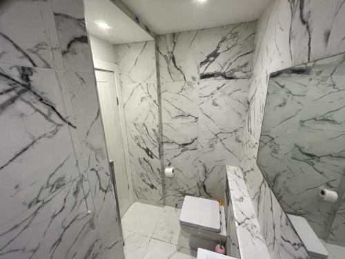 a bathroom with a toilet and a marble wall at The Old Wig Shop in Southport