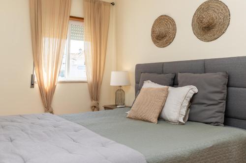 a bedroom with a bed with pillows and a window at Cabanas Green Apartment & Loft. in Cabanas de Tavira