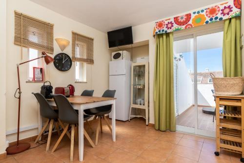 a kitchen and dining room with a table and chairs at Cabanas Green Apartment & Loft. in Cabanas de Tavira