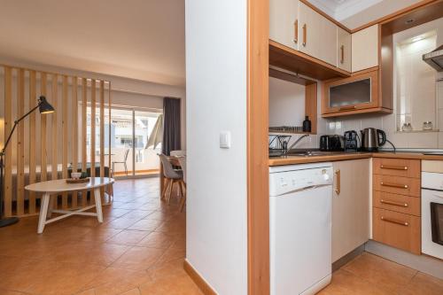 a kitchen and living room with a table and a table at Cabanas Green Apartment & Loft. in Cabanas de Tavira